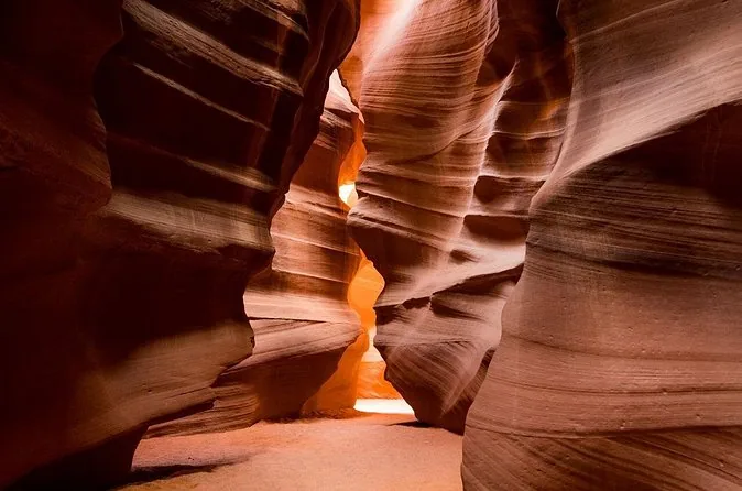 Light glowing on the curved walls of a narrow slot canyon